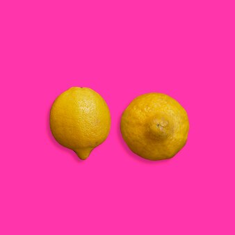 Gelbe zitronen auf einem rosa hintergrund-brustkrebskonzept