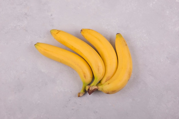 Gelber Bananenbündel lokalisiert auf Beton in der Mitte