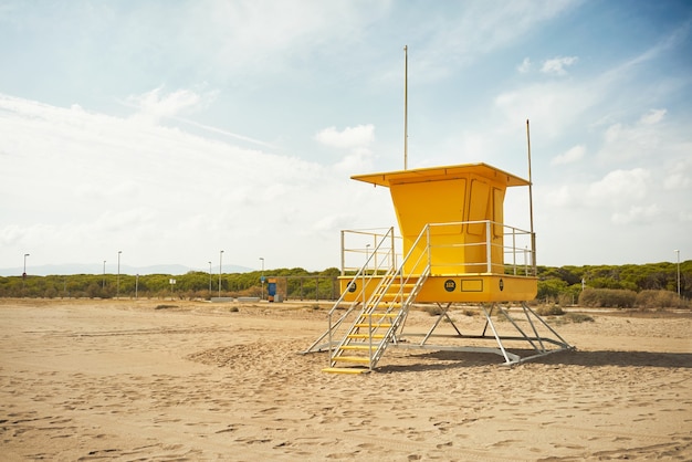 Gelber Rettungsschwimmerpfosten an einem leeren Strand