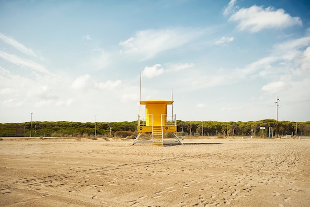 Gelber Rettungsschwimmerpfosten an einem leeren Strand