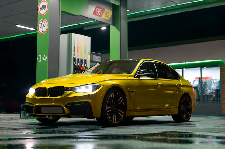 Kostenlose Foto gelbes auto an einer tankstelle