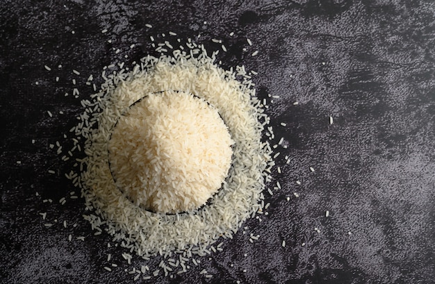 Gemahlener Reis in einer schwarzen Schüssel auf dem schwarzen Zementboden.