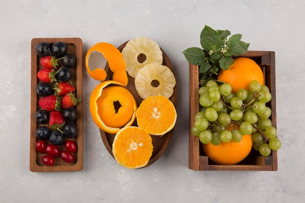 Gemischte Früchte und Beeren in Holzplatten in der Mitte