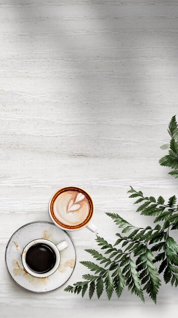 Gemischte Kaffeetassen mit einem Blatt auf einer weißen strukturierten Holztapete