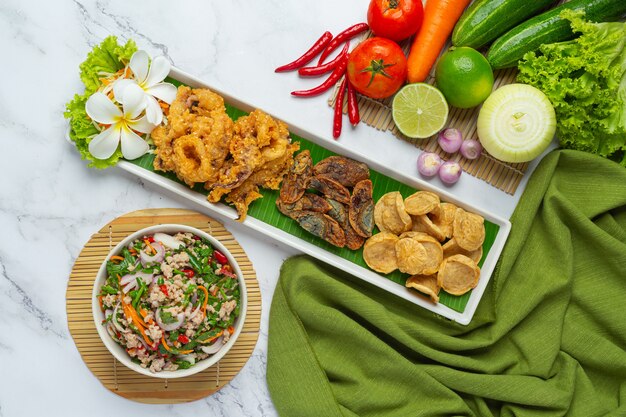 Gemischter würziger Salat mit vietnamesischer Wurst, eingelegtem Ei und knusprigem Tintenfisch, thailändisches Essen.