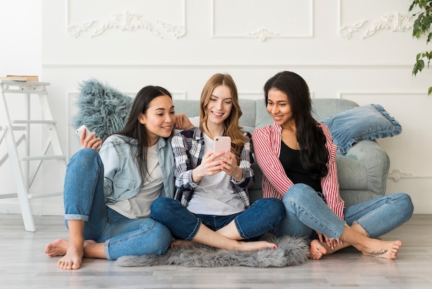 Gemischtrassige Freundinnen fotografiert am Telefon