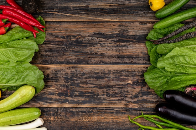 Gemüse auf der rechten und linken Seite des Rahmens auf einem Holztisch