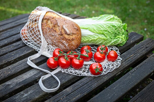 Gemüse und Brot in einer Einkaufstasche auf einer Holzoberfläche