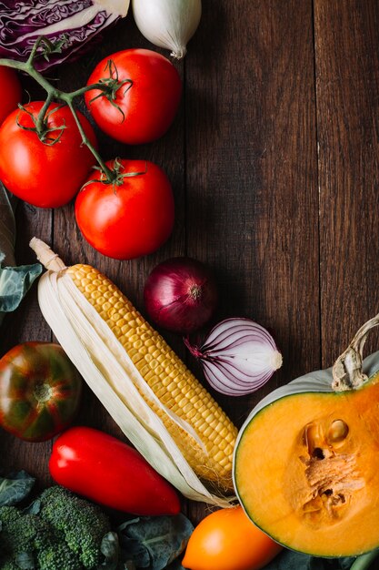 Gemüse und Tomaten auf hölzernem Kopienraumhintergrund