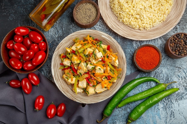 Gemüsehühnchensalat von oben mit Tomaten auf dem hellen Schreibtisch