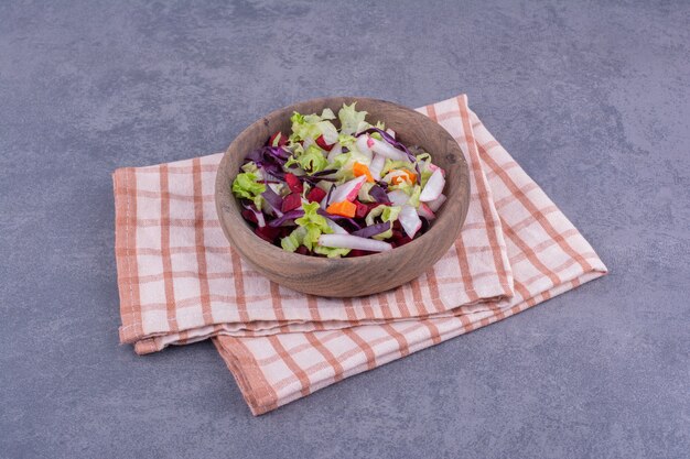 Gemüsesalat in einer Holzplatte mit gemischten Zutaten