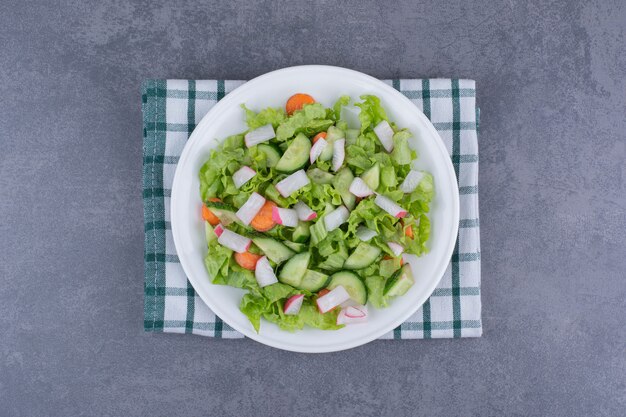 Gemüsesalat mit gemischten Zutaten auf einem karierten Küchentuch