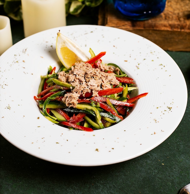 Gemüsesalat mit Gurke, Paprika, Hühnchen und Zitrone in Olivenöl.