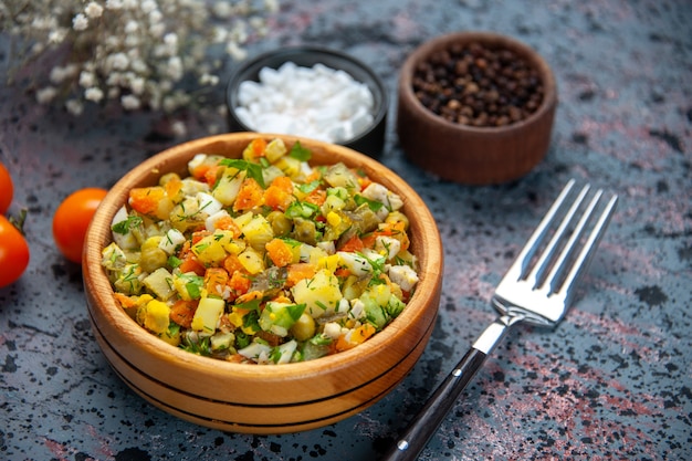 Gemüsesalat von vorne aus der Nähe mit Gewürzen auf blauem Hintergrund