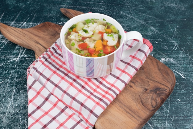 Gemüsesuppe auf Holzbrett mit Tischdecke. Hochwertiges Foto