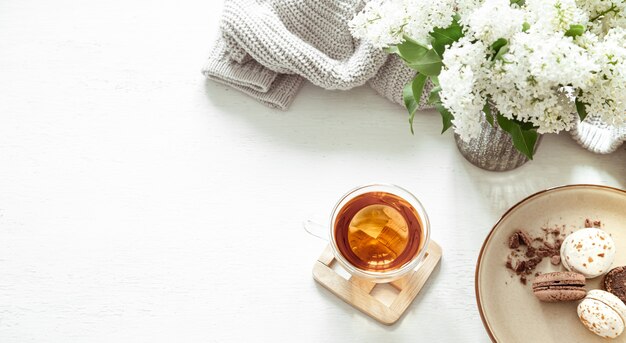 Gemütliche Frühlingskomposition mit Tee und blühendem Flieder. Ansicht von oben, flach