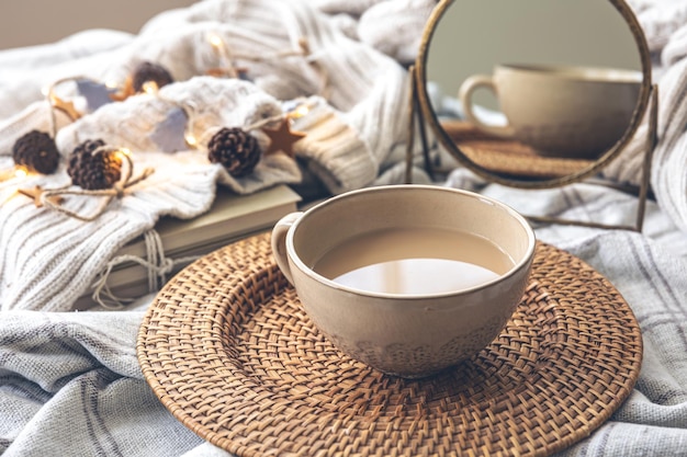 Gemütliche herbstkomposition mit einer großen tasse kaffee im bett