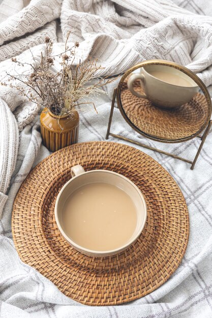 Gemütliche Herbstkomposition mit einer Tasse Kaffee und Kerzen im Bett