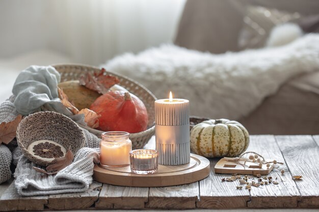 Gemütliche Herbstkomposition mit Kerzen und Kürbissen in einem Wohnhaus.