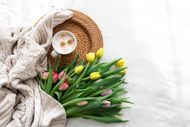 Gemütliche Komposition mit Blumen und Kaffee auf einer Draufsicht des weißen Hintergrundes