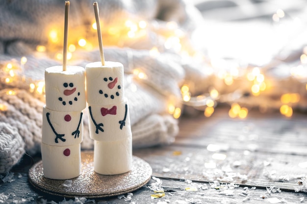 Kostenloses Foto gemütlicher weihnachtshintergrund mit marshmallow-schneemännern und festlichem dekor