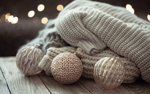 Gemütlicher Weihnachtshintergrund mit Weihnachtsschmuck und gestricktem Element auf unscharfem Hintergrund.