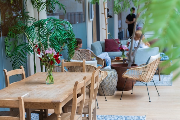 Gemütliches café im hotel mit grünen pflanzen und blumen dekoriert