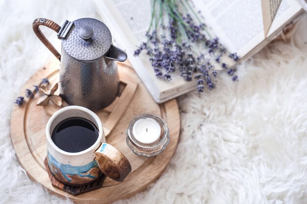 Gemütliches Stillleben mit Wasserkocher und einer Tasse heißem Getränk