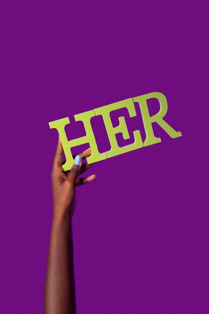 Gender Fluid Person, die ein Pronomen isoliert auf Lila hält