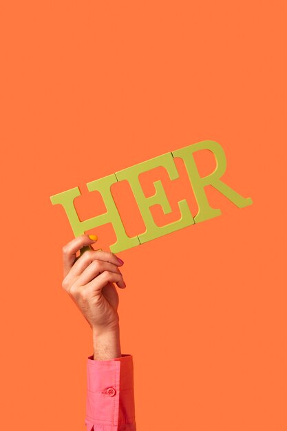 Gender Fluid Person, die ein Pronomen isoliert auf Orange hält