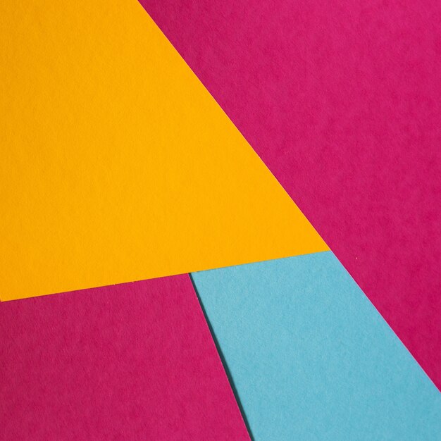 Geometrischer flacher Lagehintergrund des blauen, rosa, gelben Pastellfarbpapiers.