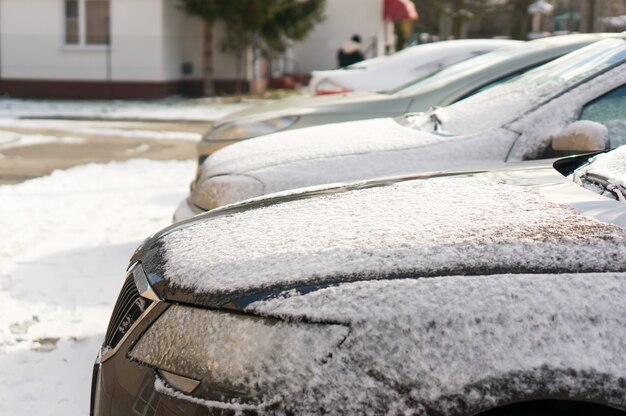 Geparkte Autos an einem verschneiten Tag.