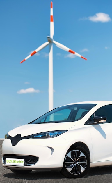 Kostenloses Foto geparktes elektroauto mit windmühle