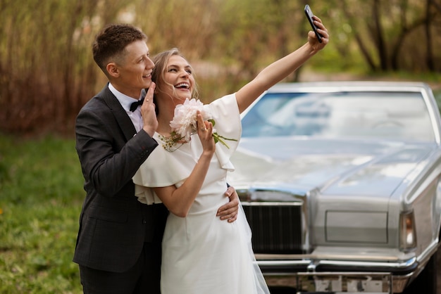 Kostenloses Foto gerade verheiratetes paar mit ihrem auto