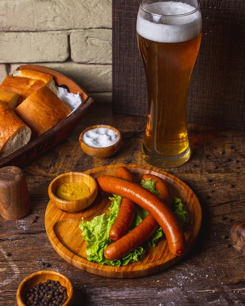 Kostenloses Foto geräucherte würstchen mit salat, senf und bier