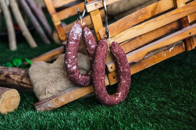 Geräucherte Würste auf Gras mit Holzkisten auf der Rückseitenansicht