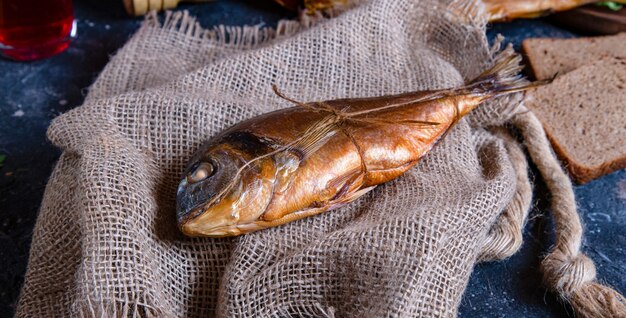 Geräucherter ganzer trockener Fisch auf einem Stück rustikalem Gewebe