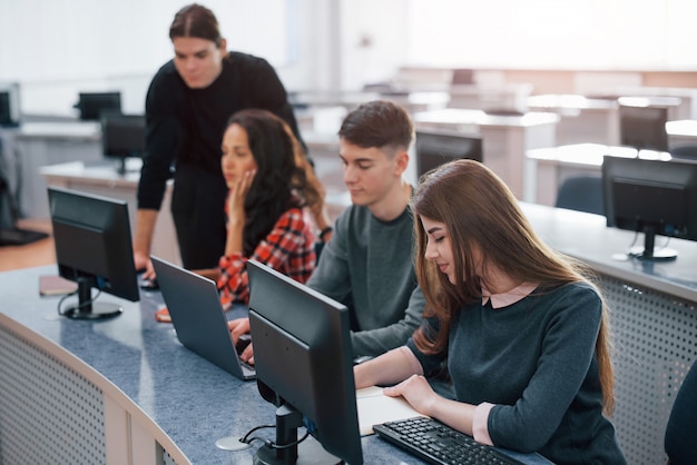 Geräumiger Bereich. Gruppe junger Leute in Freizeitkleidung, die im modernen Büro arbeiten