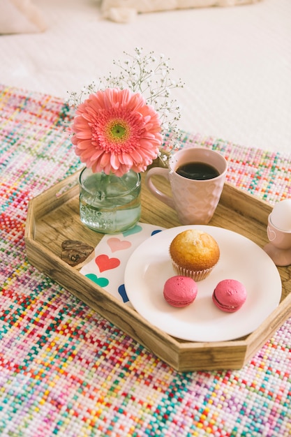 Gerberablume mit Makronen und Kaffee auf Tellersegment