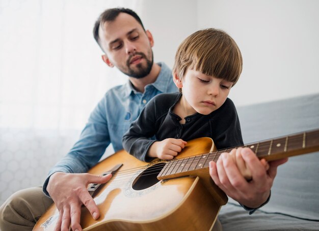 Geringer Winkel des Gitarrenunterrichts mit Kind
