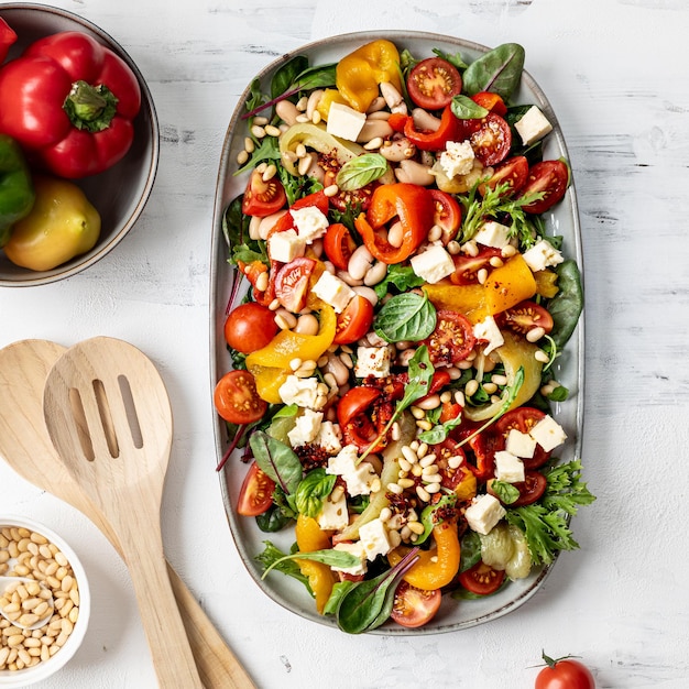 Gerösteter Pfeffer- und Butterbohlensalat mit Harissa-Dressing auf weißem Hintergrund