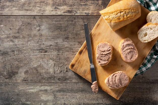 Geröstetes Brot mit Schweineleberpastete auf Holztisch