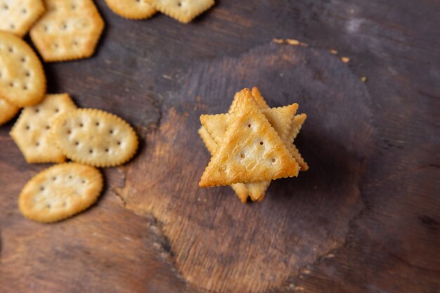 Gesalzene Cracker der Draufsicht auf dem knackigen Crackersnackfoto des hölzernen Schreibtisches