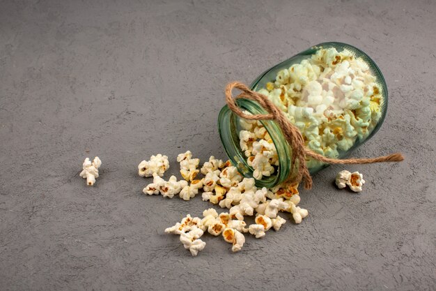 Gesalzenes Popcorn lecker hell innen und außen Glasdose auf einem Grau