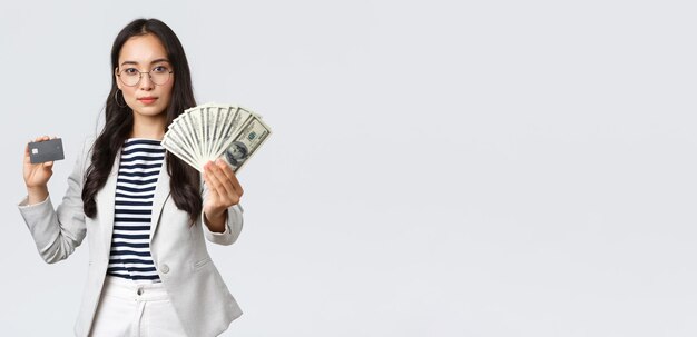 Geschäftsfinanzierung und Beschäftigung Unternehmer und Geldkonzept Erfolgreiche asiatische Geschäftsfrau, die zeigt, wie die Einkommenssteigerung Kreditkarte und Geld lächelnde Kamera hält