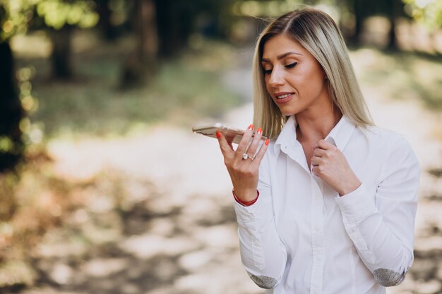 Geschäftsfrau, die am Telefon im Park spricht