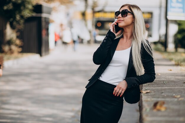 Geschäftsfrau, die am Telefon in der Straße spricht