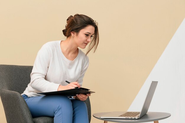 Geschäftsfrau, die beim Sitzen an einem Laptop arbeitet