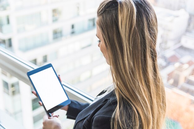 Geschäftsfrau, die digitale Tablette mit weißem Bildschirm betrachtet
