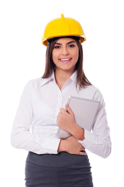 Geschäftsfrau, die Helm hält, der digitales Tablett hält